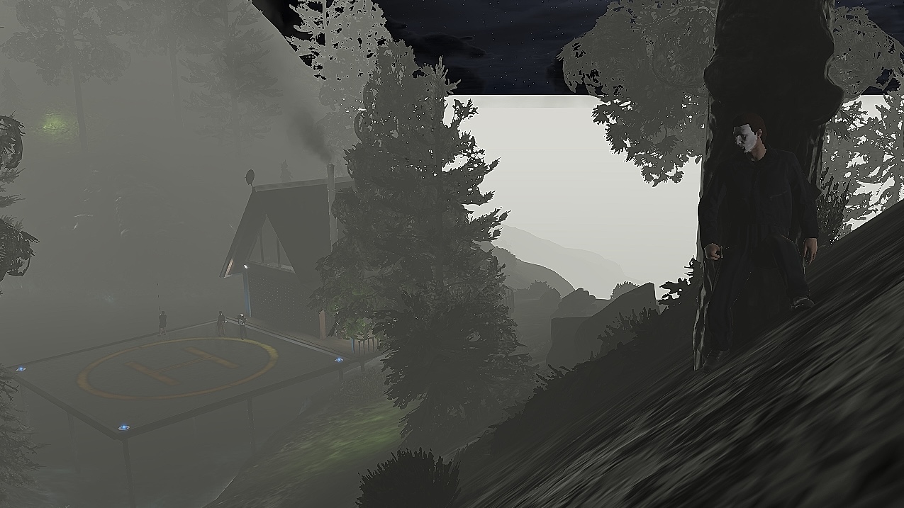 A masked figure in dark clothing stands beside a tree on a foggy hillside above the Mount Gordo Lakehouse and helipad